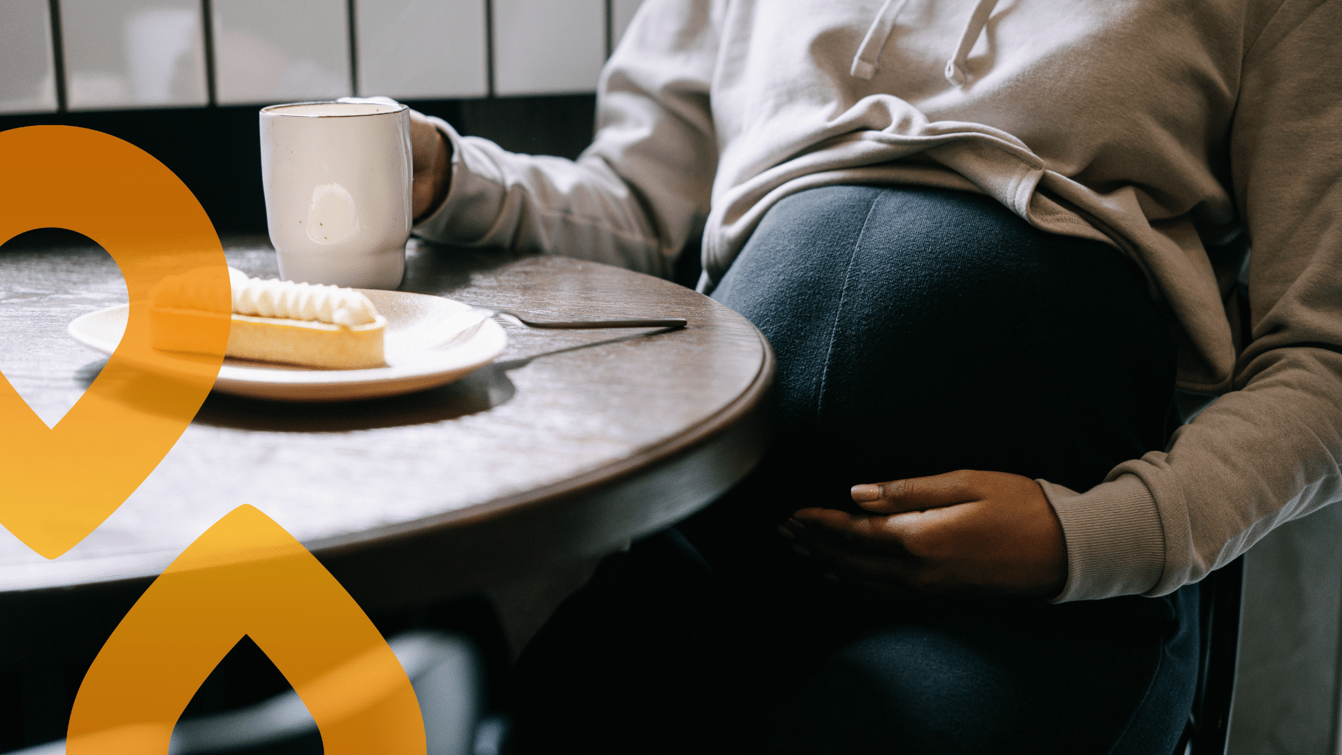 raskana oleva henkilö istuu kahvilassa