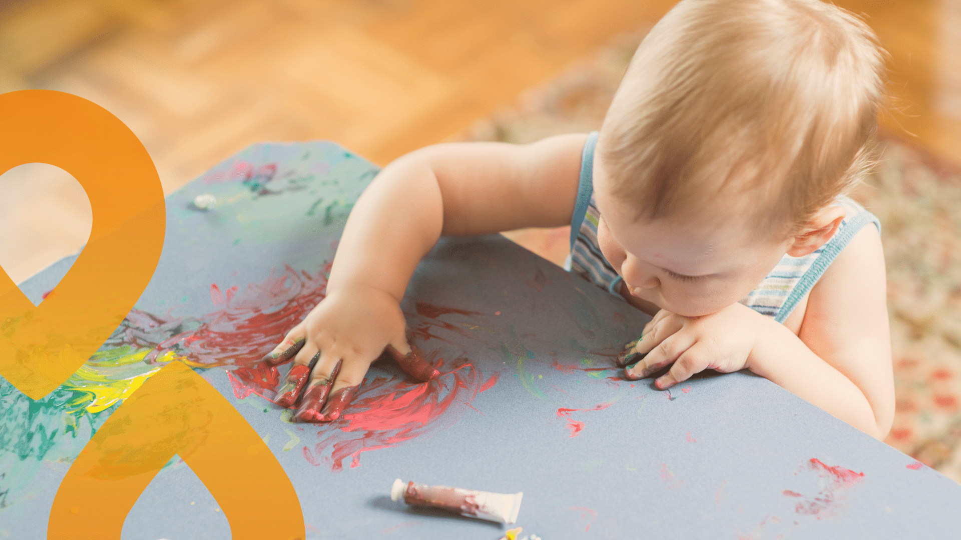 vauva maalaamassa sormiväreillä