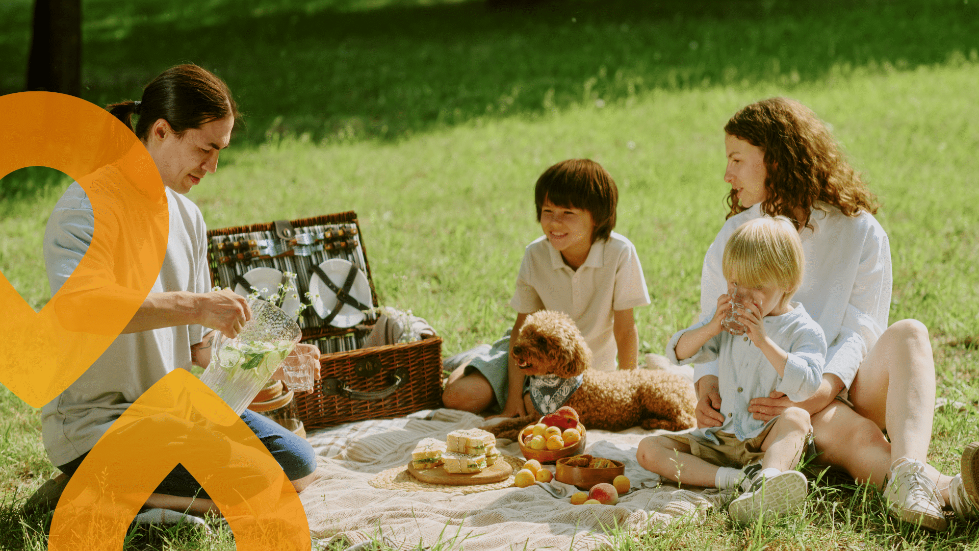 Aikuisia ja lapsia picnicillä, mukana koira