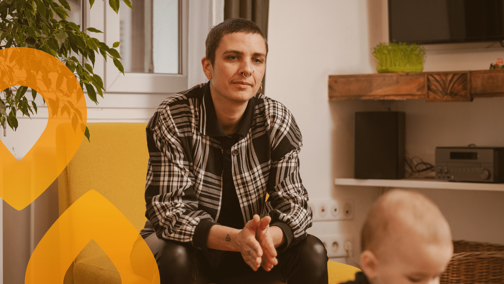 Aikuinen istuu sohvalla, edessään vauva